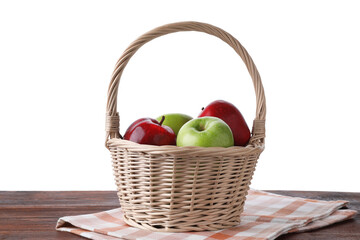 Red and green ripe apples in wicker basket on wooden table against white background