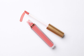 Beautiful lip gloss with applicator on white background, top view