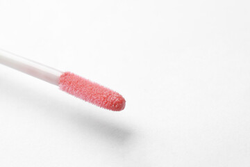 Lip gloss applicator on white background, closeup. Space for text