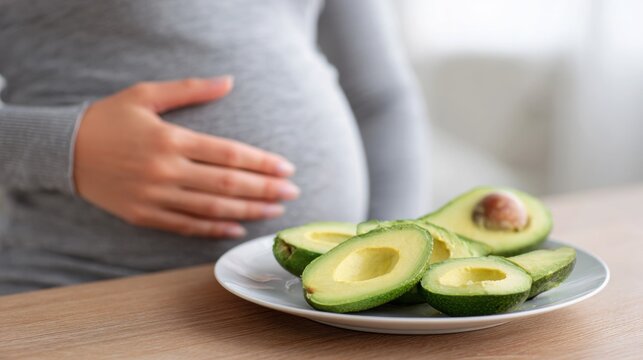 Sliced Avocado on Plate Next to Woman Holding Her Belly, Symbolizing Healthy Eating and Fat-Burning Foods - Powered by Adobe