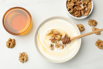 Delicious Greek yogurt with honey and nuts on white table, flat lay