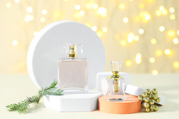 Stylish presentation of perfume and Christmas decor on table against beige background with blurred lights, closeup with bokeh effect. Mockup for design