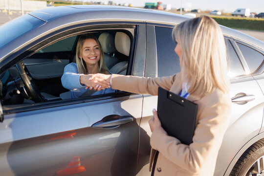 Learner Driver Shaking Hands with Instructor after Successful Driving Test