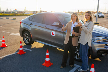 Learner Driver and Instructor Showing Passed Driving License at Test Area
