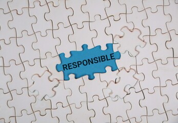 A white puzzle highlighting the word "RESPONSIBLE" on an blue background. Conveying themes of accountability, teamwork, and problem solving.