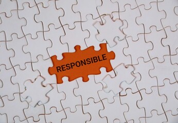 A white puzzle highlighting the word "RESPONSIBLE" on an orange background. Conveying themes of accountability, teamwork, and problem solving.
