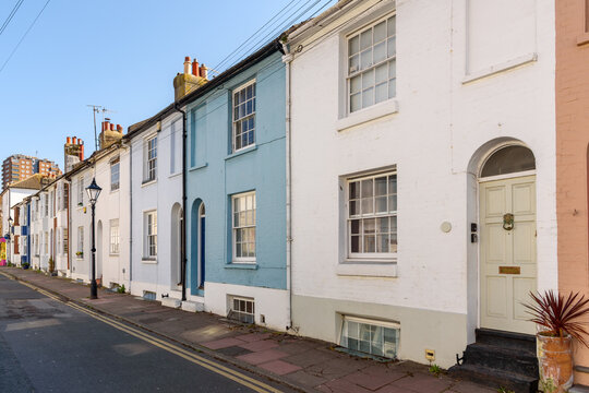 Traditional colourful British terraced houses along a stone pavement on a sunny spring morning