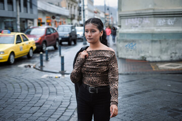 Young woman wearing leopard print blouse on urban street. Fashion day