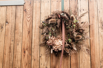 Rustic wreath of dried flowers on wood