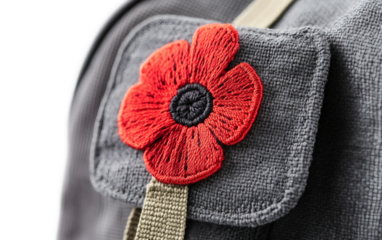 Detailed shot of decorative red poppy patch sewn onto backpack fabric isolated on transparent background PNG