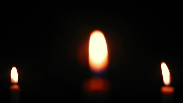 A candle burning in the dark, without electricity, darkness, ritual. Night space glowing softly with flickering light. Calm reflective mood.
