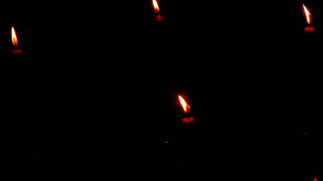A candle burning in the dark, without electricity, darkness, ritual. Night space glowing softly with flickering light. Calm reflective mood.