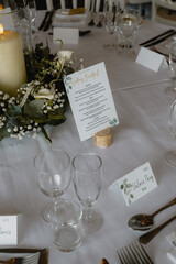 A table with a candle, a menu, and a set of wine glasses