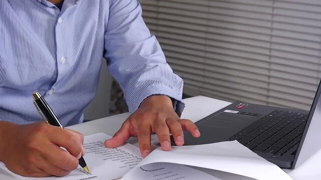 Opening a file sheet. A person checks off a to-do list. Checking all status checklist boxes. Close up of hand holding pen and checking financial list on work desk

