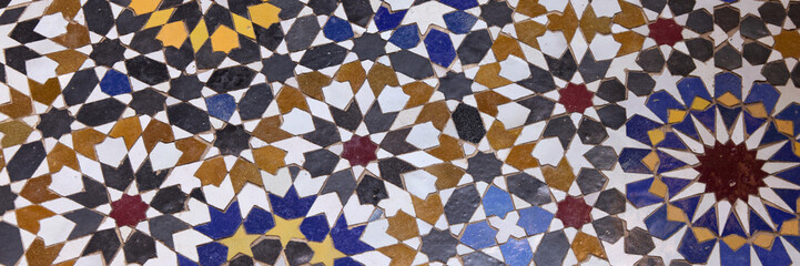 Ceramics students in Fez create stunning tile designs with vibrant colors and complex shapes, showcasing their traditional craft skills and artistic talent in a historic school setting