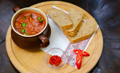 Food photography of red lentil soup with chili and bacon, carrot, onion, garlic, toasted bread, broth, stock, set table. High quality photo