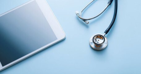 Close-up of a stethoscope and digital tablet on a light blue surface representing modern healthcare technology and medical diagnostics