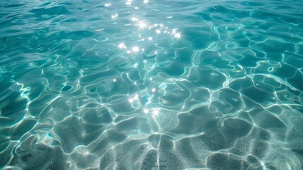 Obraz premium Sparkling sun reflections on a clear turquoise water surface. Abstract summer background of a rippling sea or swimming pool