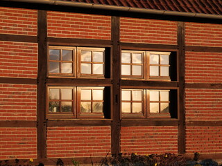 Lattice windows in the evening sunlight, half-timbered house on a farm