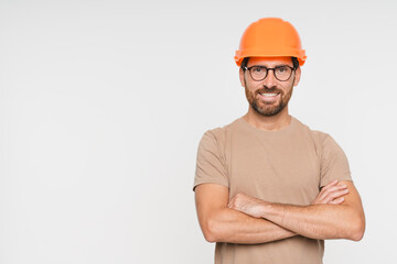 Construction worker man with crossed arms and smile, architect or engineer in building industry on white studio background. Professional builder male contractor with helmet, mockup copy space.
