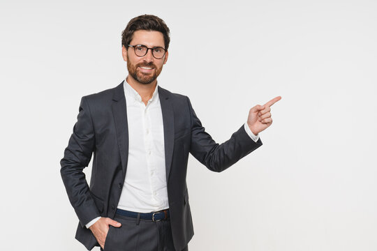 Man in business attire points with index finger to branding product placement and advertising, isolated white background. Businessman exudes a professional yet approachable demeanor, copy space
