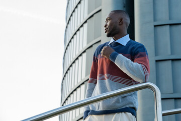 Stylish man in colorful sweater enjoying the city view on a bright sunny day