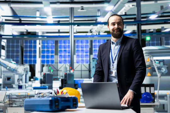 Professional inspector in a suit reviewing solar panel production, showcasing leadership in renewable energy industry. Ensure industrial operations within a modern manufacturing facility.
