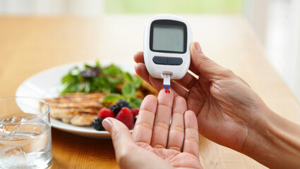 Person measuring blood sugar levels with a glucometer before consuming a healthy, balanced meal including protein, fresh berries, and green salad, managing diabetes with diet