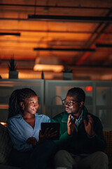 Couple interacting with tablet at night