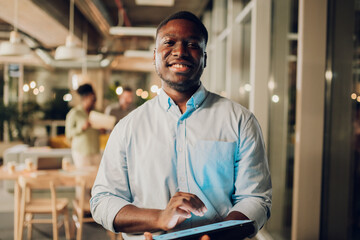 Black entrepreneur smiling while using digital tablet