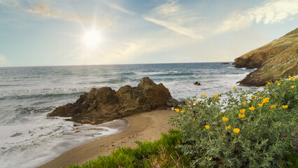 Serene coastal view at sunset with waves crashing on rocky shore. Crete, Greece.