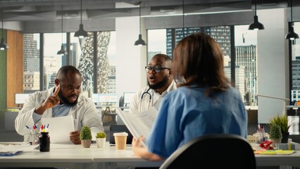 Physicians and nurses group working in a healthcare meeting to review patient care to share insight and hospital records. Focuses on treatment planning and advancement in clinic.