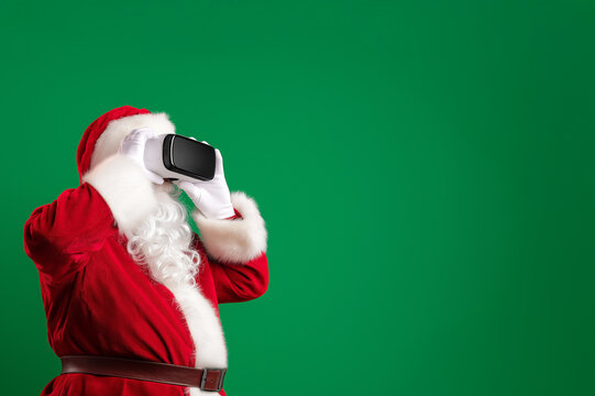 Santa Using Virtual Reality Headset on Green Background for Christmas Advertising, Technology and E-commerce Holiday Campaign