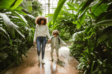 Mother talking and holding hands with her smiling son as they walk