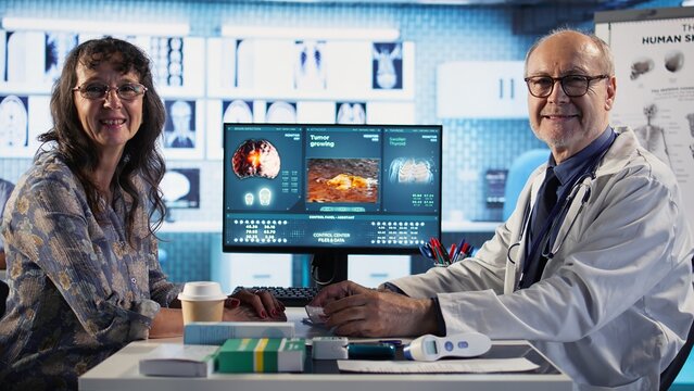 Doctor provides cancer screening guidance to a patient discussing MRI scans and tumor growth. Early detection and preventative medicine emphasized for better health outcomes. Camera A.
