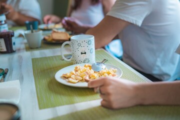 family having breakfast, only their hands and the plates on the table are shown