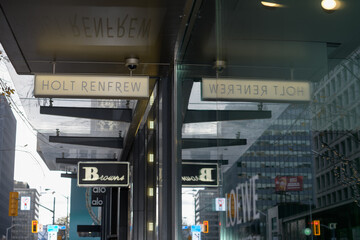 Fototapeta premium reflection of signs outside Holt Renfrew and Browns on Bloor St W, Bloor Yorkville, Toronto