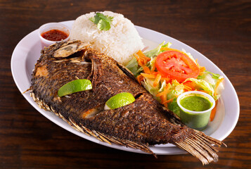 Peruvian fish platter with whole fish served with garden salad, white rice and sauces; copy space