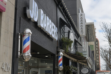 Fototapeta premium signs of Eglinton Av W, incl JD Barbers at 424 Eglinton Av W, Toronto