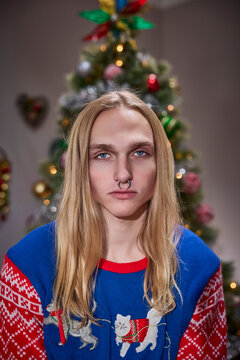 Alternative Christmas portrait featuring septum piercing and festive cat sweater with decorated tree background