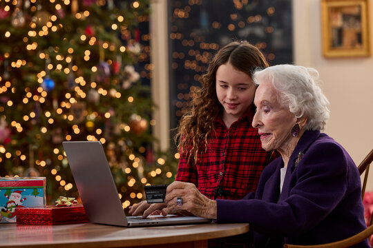 Grandmother and granddaughter shopping online together with credit card during Christmas holiday season