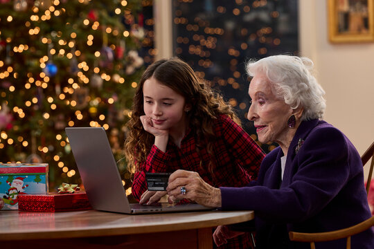 Grandmother and granddaughter shopping online together with credit card during the Christmas holiday season