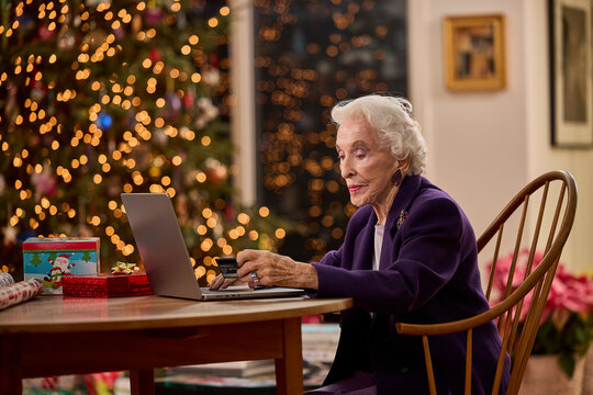 Senior woman shopping online with laptop at home during the Christmas holiday season