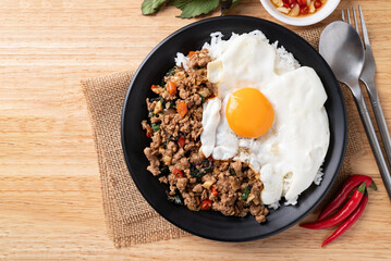 Thai food, Stir fried holy basil with minced pork with cooked rice and fried egg on top, Table top view