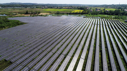 A high-resolution image of modern solar panels installed on a residential or commercial rooftop, under a bright blue sky. The photo emphasizes renewable energy, environmental sustainability, and moder