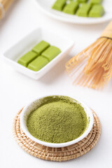 Matcha powder and chocolate bar on white background