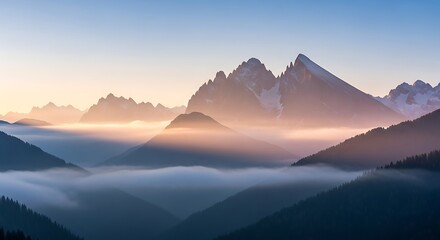 Misty mountain range with layers of fog at sunrise.