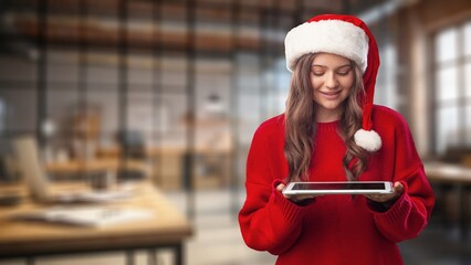Girl in santa hat holds digital tablet Buying Christmas gifts