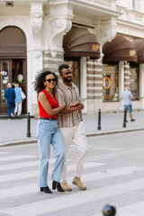 Fototapeta premium A man and a woman cross the road and hold hands while smiling