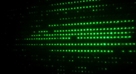 Glowing green grid pattern of bright dots on black. A futuristic, abstract design